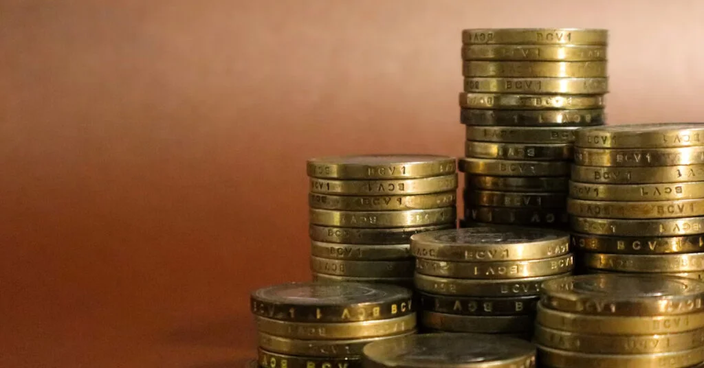 أكوام من العملات الذهبية متصاعدة الحجم على خلفية بنية ترمز لبناء الأصول وتراكم الثروة
